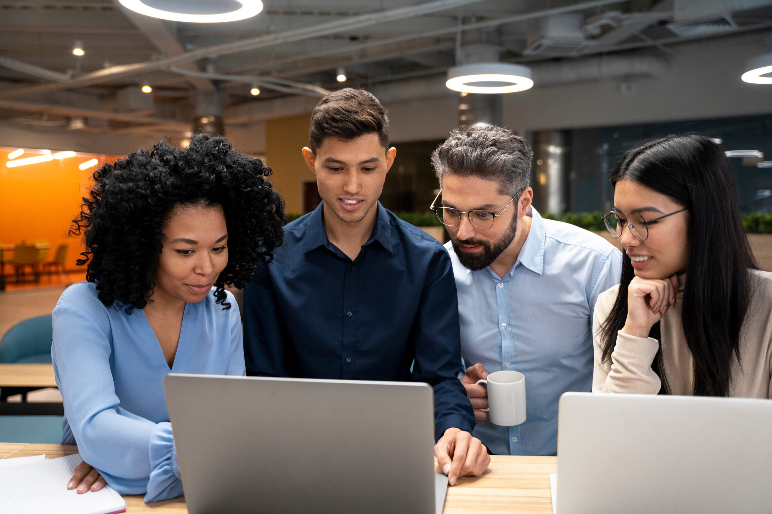 Team collaborating around a laptop